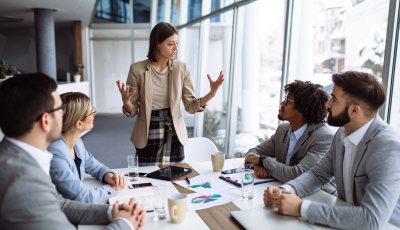 1 Woman leading a meeting of peers in a conference room